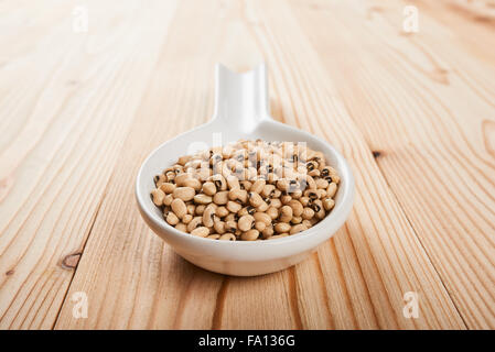 Auge-Bohnen auf Keramik Löffel und weißer Holztisch Stockfoto