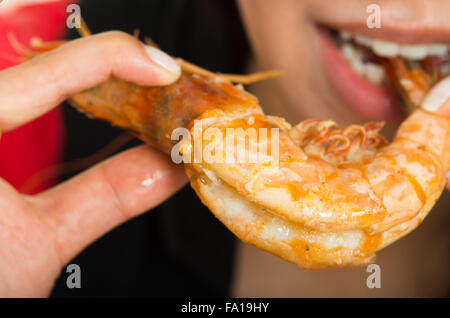 Aufnahme der jungen Frau eine große Garnelen essen Nahaufnahme Stockfoto