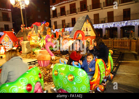 Torrejon de Ardoz, Spanien 19. Dezember 2015: Familien genießen Sie eine Fahrt auf eine bunte Raupe Zug in den wichtigsten Platz von Torrejon de Ardoz, einer Stadt etwa 20 km von Madrid entfernt. Jedes Jahr ist die Stadt aufwendig zu Weihnachten mit Lichtern und dem Hauptplatz gefüllt mit Attraktionen für Kinder und Familien, einschließlich der große Figuren aus Märchen und Geschichten für Kinder eingerichtet. Bildnachweis: James Brunker/Alamy Live-Nachrichten Stockfoto