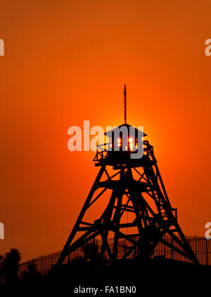 Aufgehende Sonne, die in einem rauchigen Himmel hinter dem historischen Feuerturm in helena, montana, leuchtet Stockfoto