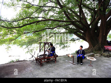 Qiandongnan, Chinas Provinz Guizhou. 19. Dezember 2015. Frauen von Dong ethnische Gruppe gestalten Baumwollgarnen um traditionelle Dong Stoff in Lexiang Dorf von Rongjiang County, Südwesten Chinas Provinz Guizhou, 19. Dezember 2015 zu weben. Das handgefertigte Tuch dient hauptsächlich von einheimischen Trachten Dong ethnischen Gruppe zu machen. © Wu Jibin/Xinhua/Alamy Live-Nachrichten Stockfoto