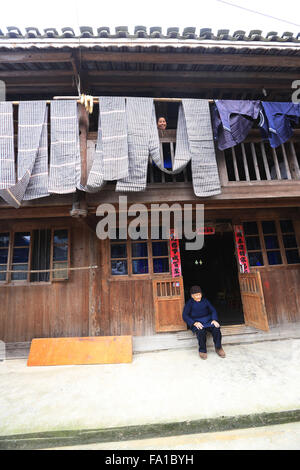 Qiandongnan, Chinas Provinz Guizhou. 19. Dezember 2015. Eine Frau Dong ethnischen Gruppe lüftet das handgewebte Tuch in Lexiang Dorf von Rongjiang County, Südwesten Chinas Provinz Guizhou, 19. Dezember 2015. Das handgefertigte Tuch dient hauptsächlich von einheimischen Trachten Dong ethnischen Gruppe zu machen. © Wu Jibin/Xinhua/Alamy Live-Nachrichten Stockfoto