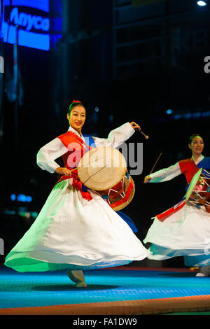 Eine koreanische Frauen in weißen flatternden Hanbok Spinnen zeigen Quirlen und traditionellen Janggu Schlagzeug zu spielen, kostenlos nachts Stockfoto