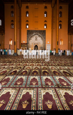 Muslimische Männer Schlange vor einer großen Wand für Abendgebet in der Gebetsraum in der Main-Moschee Jama Masjid Stockfoto