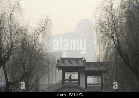 Peking, China. 20. Dezember 2015. Ein Mann geht an einem Smog gehüllten Park im Zentrum von Peking, die Hauptstadt von China, 20. Dezember 2015. Beijing hat seine zweite Alarmstufe Rot für die Luftverschmutzung in diesem Monat ein neuen Anfall von Smog zu rechnen ist, um die Hauptstadt von Samstag bis Dienstag zu schlagen. Bildnachweis: Wu Wei/Xinhua/Alamy Live-Nachrichten Stockfoto