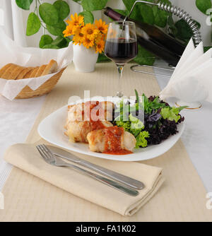 Huhn rollt gefüllt mit Käse, eingewickelt in Speck und Kräuter in einer Tomaten-Knoblauch-sauce Stockfoto