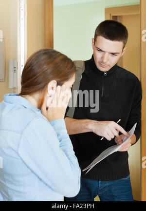 Sammler wird versuchen, die Schulden von jungen Frau zu Hause Stockfoto