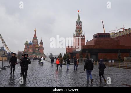 Touristen und Polizei Fuß auf dem Roten Platz entlang dem Lenin Mausoleum, Spasskaja-Turm und Basilius Kathedrale Stockfoto