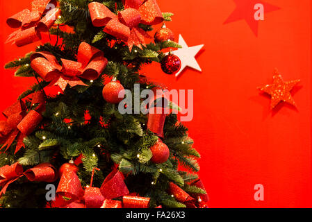 Geschmückter Weihnachtsbaum mit roten Kugeln & Bänder, UK. Stockfoto