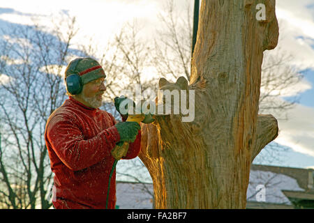 Holzschnitzer mit einem Winkelschleifer Stockfoto