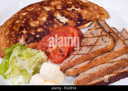 Englisches Frühstück mit Rührei, Tomaten, Kartoffeln, Toast und frischem Salat Stockfoto