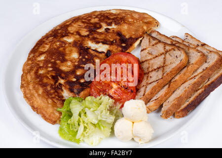 Englisches Frühstück mit Rührei, Tomaten, Kartoffeln, Toast und frischem Salat Stockfoto