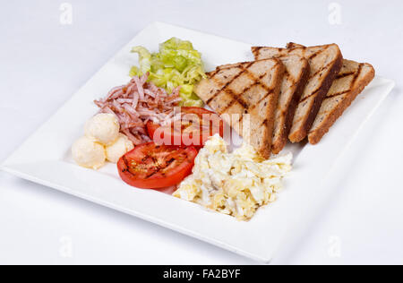 Traditionelles englisches Frühstück mit Rührei, Tomaten, Kartoffeln, Toast und frischem Salat Stockfoto