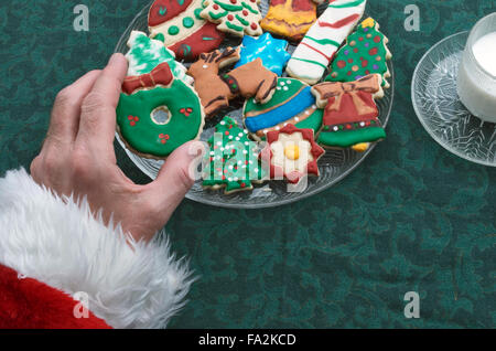 Santa Auswahl ein Weihnachtsplätzchen Ausschnitt aus der Platte, mit Glas Milch Stockfoto