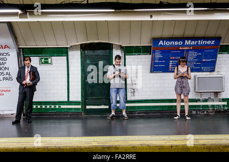 Madrid Spanien, Hispanic Chamberi, Alonzo Martinez Metro Station, U-Bahn, Zug, Mann Männer männlich, Frau weibliche Frauen, warten, Smartphone Handys SMS Stockfoto