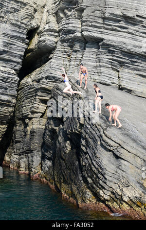 Vernazza, Italien - 7. Juli 2015: Leute springen aus einem Felsen im Meer bei Vernazza auf Cinque Terre, Italien Stockfoto