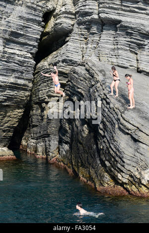 Vernazza, Italien - 7. Juli 2015: Leute springen aus einem Felsen im Meer bei Vernazza auf Cinque Terre, Italien Stockfoto