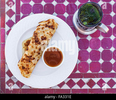 Msemen oder Rghaif ist eine typische Küche Maghreb Berber Fladenbrot. Typisches marokkanisches Frühstück, Msemen mit Honig und marokkanischen Tee Stockfoto
