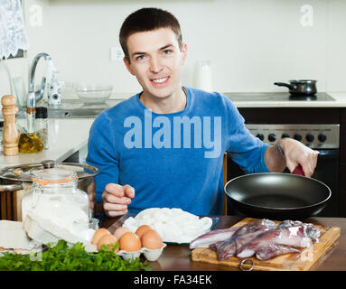 Kerl Kochen Tintenfischringe im Teig Stockfoto