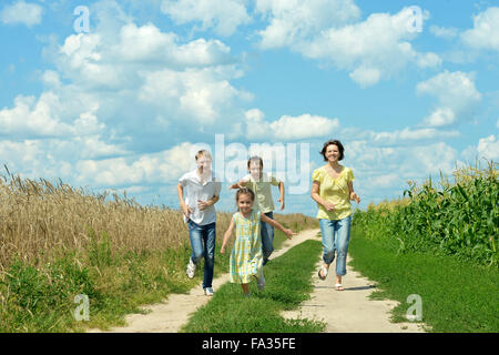 Glückliche Familie auf Feld springen Stockfoto