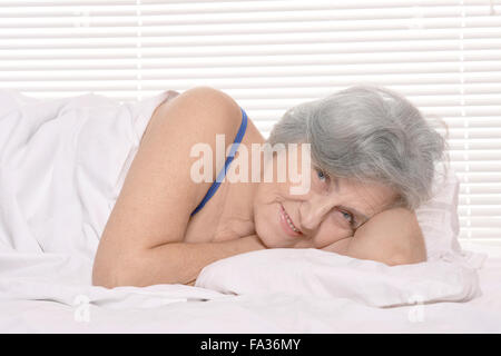 ältere Frau ruht in einem Schlafzimmer Stockfoto