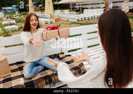 Mädchen wirft Geschenke zueinander Stockfoto