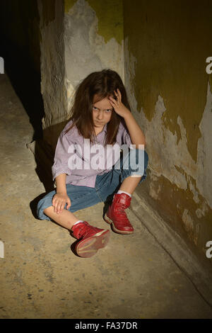 kleines Mädchen in einem dunklen Keller Stockfoto