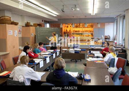 Berufsausbildung an den Verkäufer. Lehren Sie für Bäckerei spezialisierten Anbietern. Stockfoto