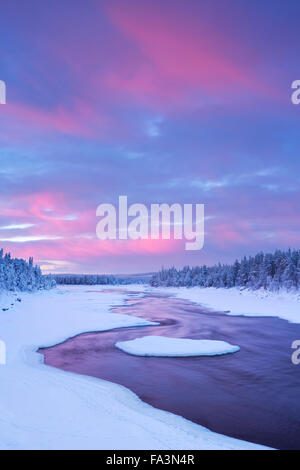 Eine schnelle in einem Fluss in eine winterliche Landschaft. Fotografiert an der Äijäkoski-Stromschnellen im Fluss Muonionjoki im finnischen Lappland im su Stockfoto