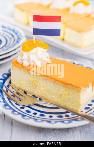 Eine orange Tompouce, traditionelle holländische Gebäck auf einem weißen Hintergrund. Das Sahnehäubchen auf der Tompouce Orange ist typisch für Königstag Stockfoto