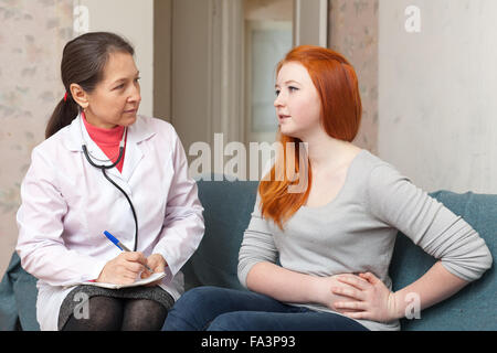 Teengirl mit Arzt über Magenschmerzen bei medizinischen Klinik beschweren Stockfoto