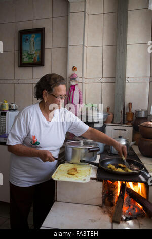 Südamerika, Brasilien, Sao Paulo. Eine lokale Frau, die in ihrer Küche auf einem holzgefeuerten traditionellen Forno einen Lenha-Herd kocht Stockfoto