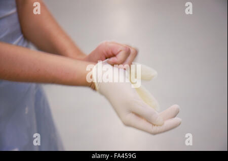 Krankenschwester nach Infektion Kontrollverfahren durch Einweg-Handschuhe anziehen, Stockfoto