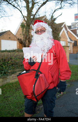 Ravenshead, Nottinghamshire, UK. 21. Dezember 2015. Ravenshead, Nottinghamshire, UK.21st Dezember 2015.Royal Mail Postarbeiter gekleidet wie Santa Claus in die festliche Stimmung in Nottinghamshire Dorf von Ravenshead.Also mit dem Wetter, so Mild für die Jahreszeit Santa tauschte seinen traditionellen roten Hosen für shorts. Bildnachweis: Ian Francis/Alamy Live-Nachrichten Stockfoto