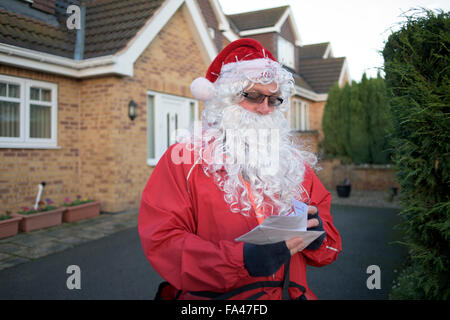 Ravenshead, Nottinghamshire, UK. 21. Dezember 2015. Königliche Post Postarbeiter als Weihnachtsmann verkleidet bekommen in die festliche Stimmung in Nottinghamshire Dorf von Ravenshead.Also mit das Wetter so mild für die Zeit des Jahres, mit dem Santa seinen traditionellen roten Hosen Shorts getauscht. Bildnachweis: Ian Francis/Alamy Live-Nachrichten Stockfoto