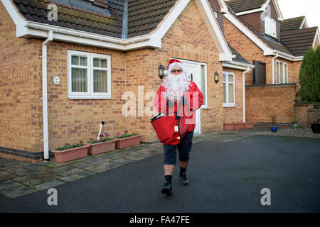 Ravenshead, Nottinghamshire, UK. 21. Dezember 2015. Königliche Post Postarbeiter als Weihnachtsmann verkleidet bekommen in die festliche Stimmung in Nottinghamshire Dorf von Ravenshead.Also mit das Wetter so mild für die Zeit des Jahres, mit dem Santa seinen traditionellen roten Hosen Shorts getauscht. Bildnachweis: Ian Francis/Alamy Live-Nachrichten Stockfoto