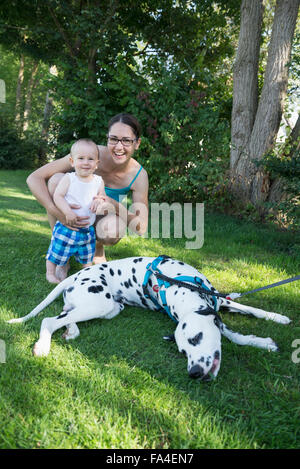 Mutter und Baby junge spielt mit Dalmatiner in Rasen, München, Bayern, Deutschland Stockfoto