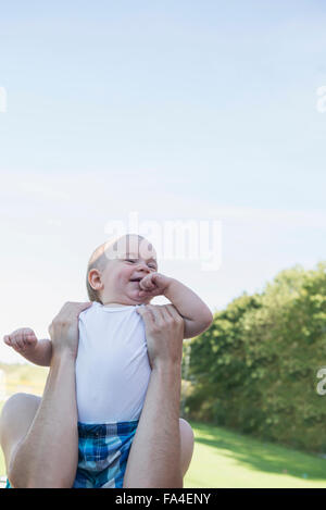 Mutter, heben Sie ihr Baby junge in Rasen, München, Bayern, Deutschland Stockfoto