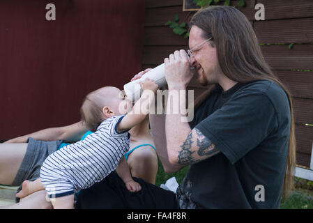 Baby Junge und sein Vater Blick durch eine Rolle Papiertücher von beiden Enden, München, Bayern, Deutschland Stockfoto