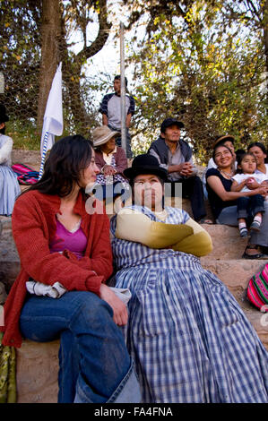 Zwei Frauen sitzen, lächelnd und plaudernd im Publikum in Luribay, Bolivien, Südamerika Stockfoto