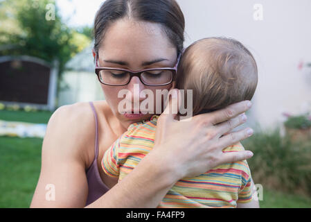 Mutter zu trösten ihr Baby Sohn in einem Rasen, München, Bayern, Deutschland Stockfoto