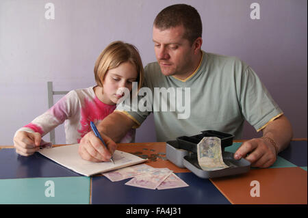 Alleinerziehende Mutter und Tochter, eine Einkaufsliste und Geld zu zählen, Stockfoto