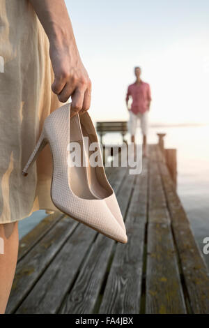 Reifer Mann wartet auf seine Frau am Pier am See, Bayern, Deutschland Stockfoto