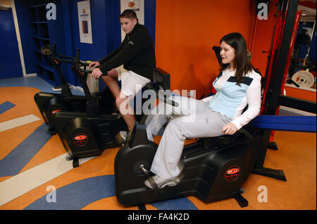 Junge und junge Frau mit Liegerad Zyklen auf eine inklusive Fitness-Studio, Stockfoto