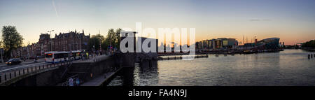 Blick auf Sonnenuntergang über Oosterdok Hafen und Nemo in Amsterdam (Noord-Holland, Niederlande). Stockfoto