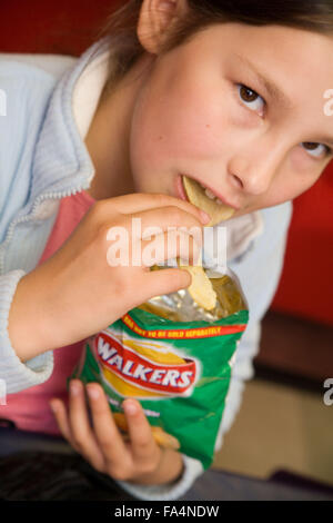 Kind essen Packung Chips, Schule Stockfoto