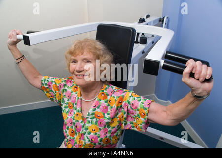 Frau mit Schulter Presse Ausrüstung in einem YMCA Fitnessstudio, Stockfoto