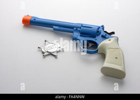 Spielzeug Pistole und Star Sheriff-Abzeichen. Stockfoto