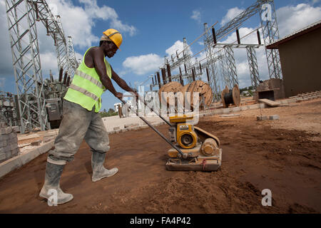 Ein Arbeiter hilft, um einen neuen elektrischen Umspannwerk in Sansibar, Tansania, Ostafrika zu bauen. Stockfoto