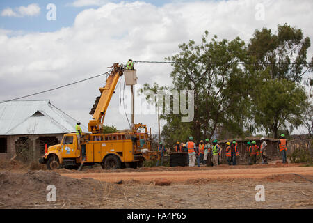 Arbeitnehmer eine Zeichenfolge neue Stromkabel in einem ländlichen Dorf in der Nähe von Dodoma, Tansania, Ostafrika. Stockfoto